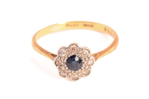 Lot 155 - A sapphire and diamond cluster ring, centred...