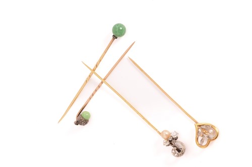 Lot 27 - Four gem-set stick pins; A heart-shaped stick...