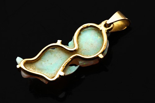 Lot 74 - A carved opal pendant, comprises precious opal...