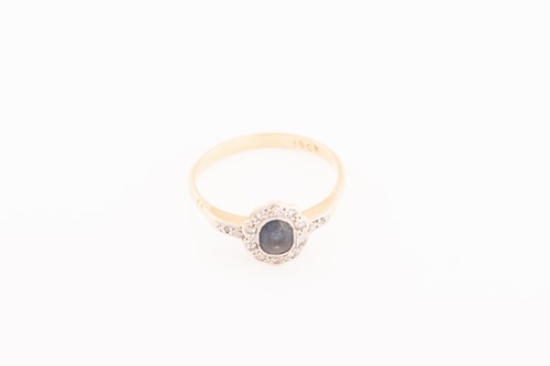 Lot 143 - A sapphire and diamond halo ring, comprises a...