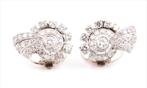 Lot 715 - A pair of diamond swirl cluster earrings the...