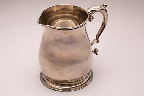 Lot 357 - A silver jug; baluster form with leaf-capped...