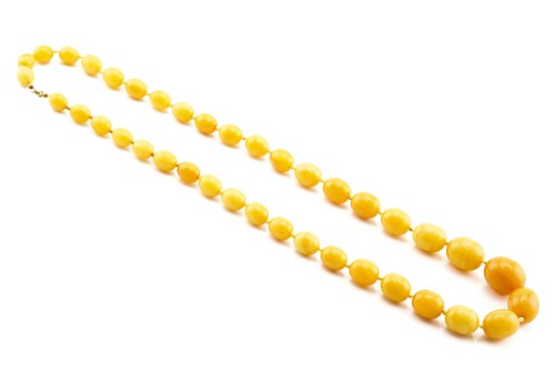 Lot 62 - A single strand graduated amber bead necklace,...