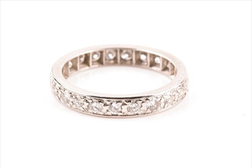 Lot 556 - A diamond eternity ring inset with round...