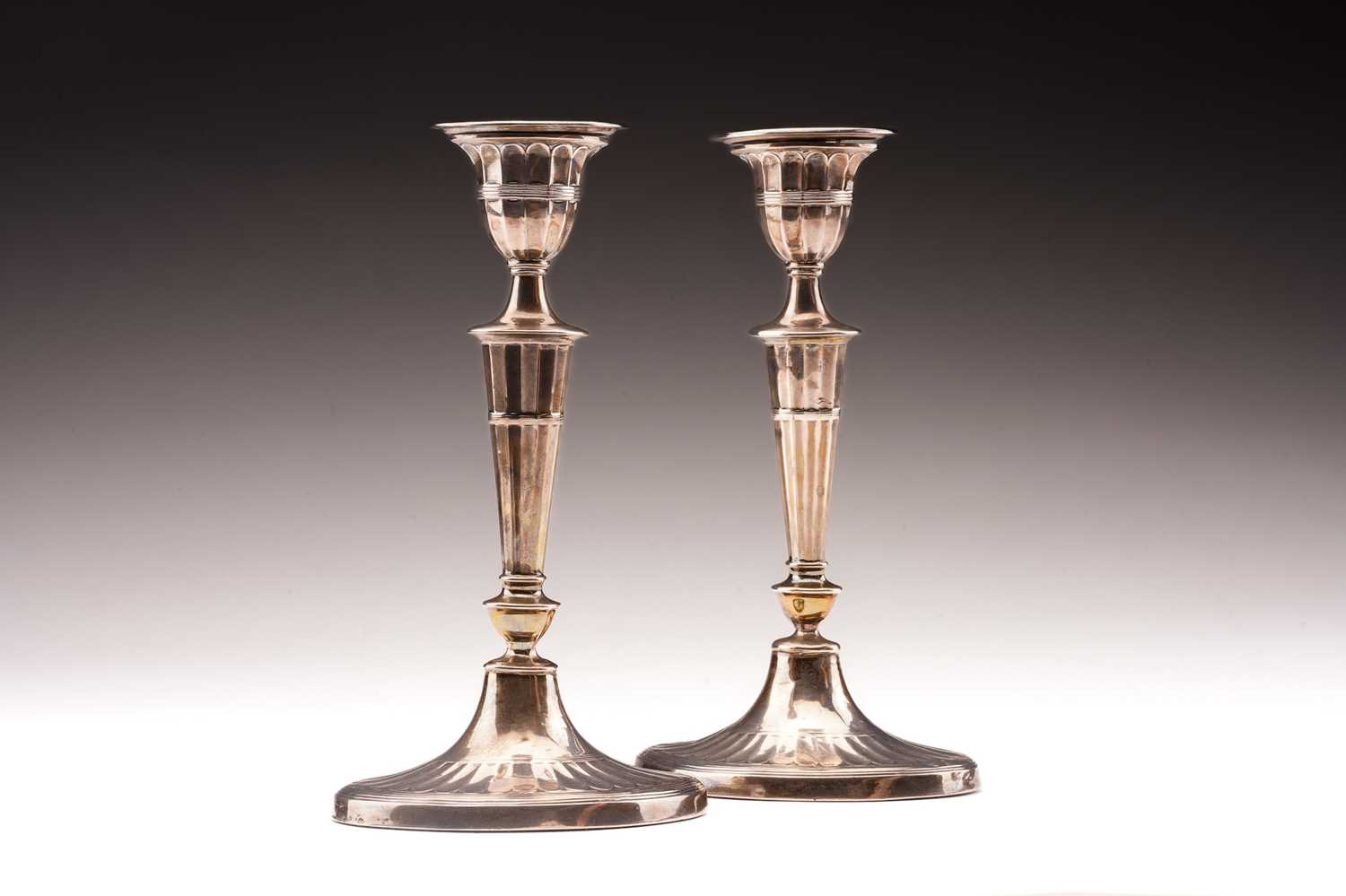 Lot 376 - A pair of George III style silver candlesticks;...
