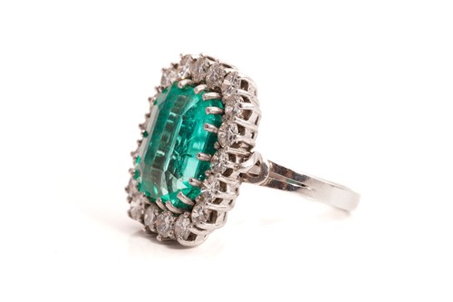 Lot 21 - An emerald and diamond entourage ring,...