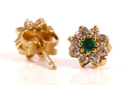 Lot 128 - A pair of emerald and diamond flowerhead...