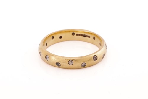 Lot 32 - A diamond etoile band ring in 18ct yellow gold,...