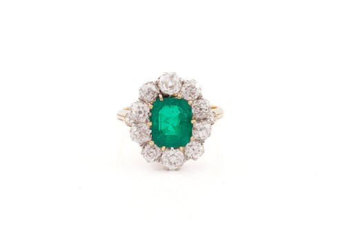 Lot 109 - An emerald and diamond entourage ring,...