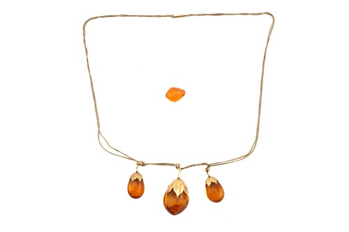 Lot 258 - An amber drop necklace and a loose amber bead;...