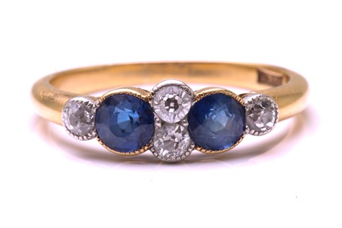 Lot 11 - A sapphire and diamond half hoop ring in 18ct...