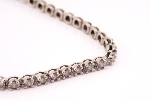Lot 89 - A diamond line bracelet in 9ct white gold,...