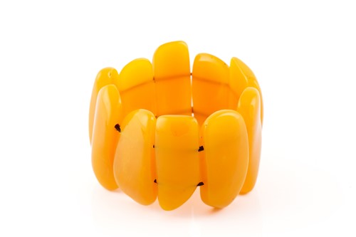 Lot 119 - An egg yolk amber panel bracelet; of ten...