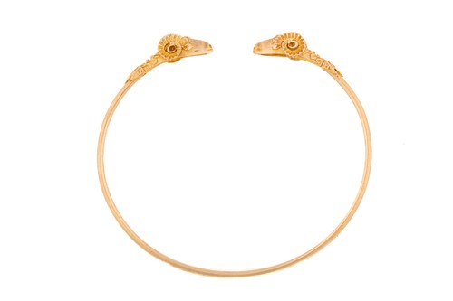 Lot 222 - A Rams head flex torque bangle with two yellow...
