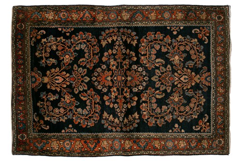 Lot 336 - An old Sarouk rug with floral sprays on an...