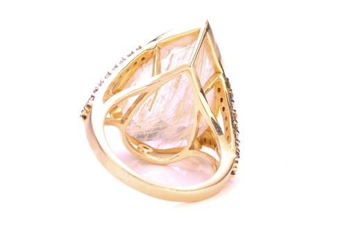 Lot 215 - A rutilated quartz dress ring, featuring...