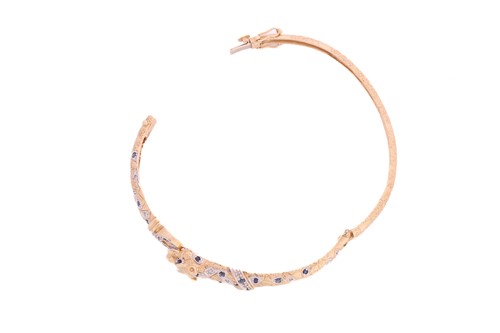 Lot 317 - A two-toned panther bangle set with sapphires...