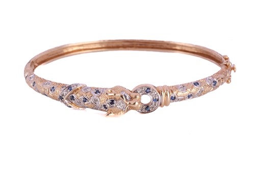 Lot 317 - A two-toned panther bangle set with sapphires...