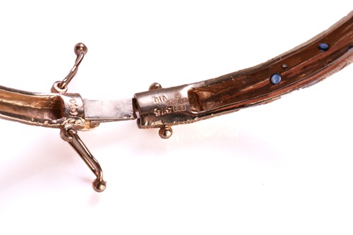 Lot 317 - A two-toned panther bangle set with sapphires...