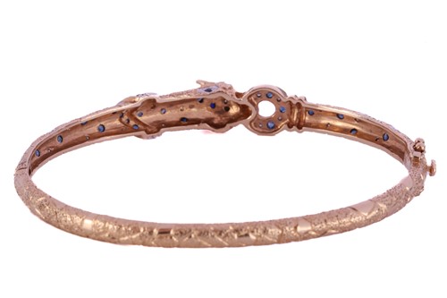 Lot 317 - A two-toned panther bangle set with sapphires...