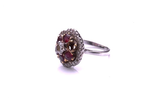 Lot 93 - A ruby and diamond cluster ring; the principal...