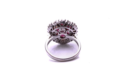 Lot 93 - A ruby and diamond cluster ring; the principal...