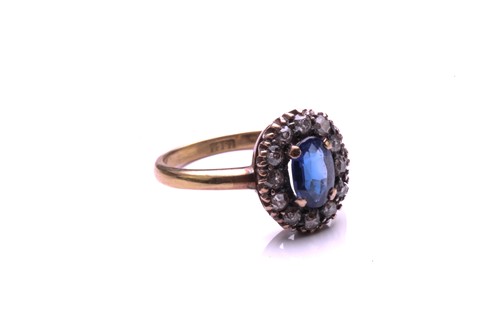 Lot 183 - A sapphire and diamond cluster ring; the oval...
