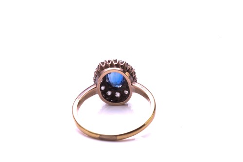 Lot 183 - A sapphire and diamond cluster ring; the oval...