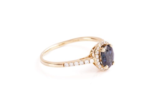 Lot 101 - A sapphire and diamond cluster ring; the oval...