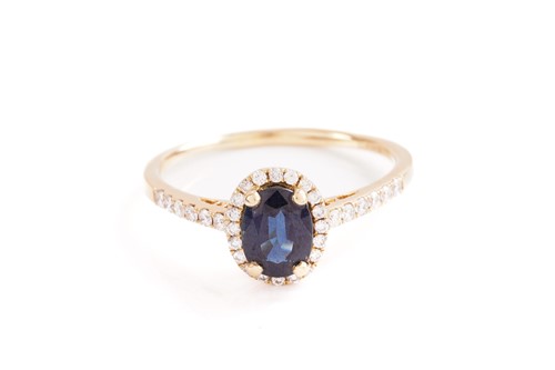 Lot 101 - A sapphire and diamond cluster ring; the oval...