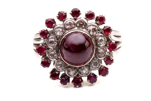 Lot 118 - A cabochon ruby and diamond cluster ring; the...