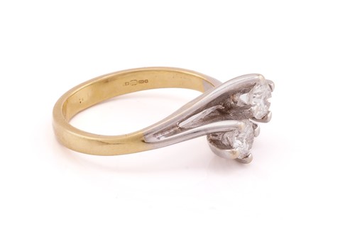Lot 13 - A two stone diamond crossover ring; the round...