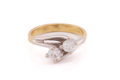 Lot 13 - A two stone diamond crossover ring; the round...