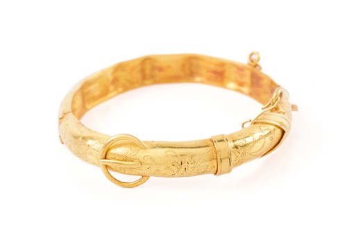 Lot 355 - A yellow gold hinged bangle, of belt form with...