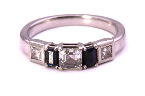 Lot 54 - A diamond and sapphire dress ring in platinum,...