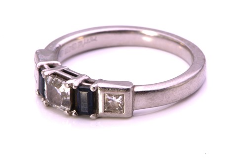 Lot 54 - A diamond and sapphire dress ring in platinum,...