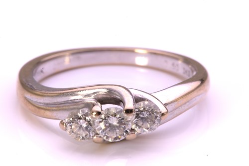 Lot 36 - A three-stone diamond crossover ring in 18ct...
