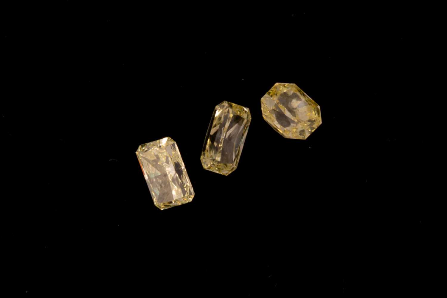 Lot 126 - Three loose light fancy yellow diamonds. Total...