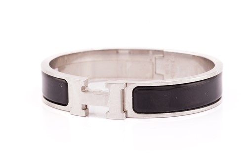 Lot 316 - Hermès - A narrow 'Clic H' bracelet with black...