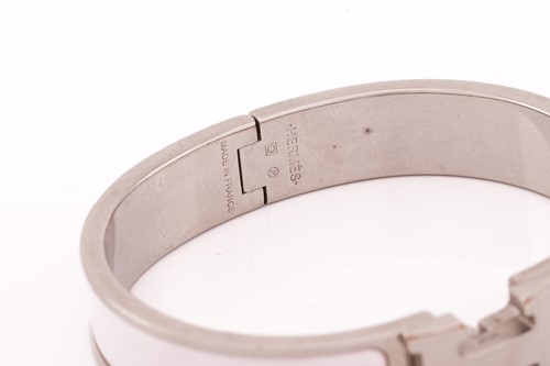 Lot 66 - Hermès - A narrow 'Clic H' bracelet with pale...