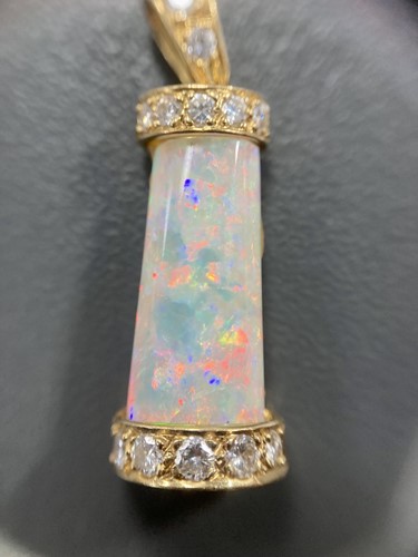 Lot 69 - An opal and diamond pendant, the tapering...