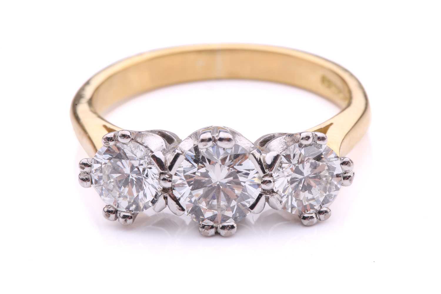 Lot 181 - A three-stone diamond half-hoop ring in 18ct...
