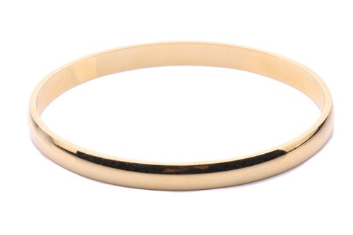 Lot 180 - A yellow metal closed bangle, with a solid...