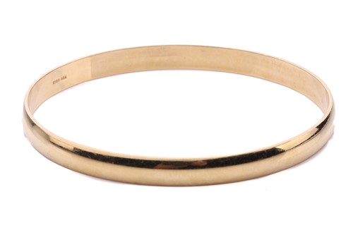 Lot 154 - A yellow metal closed bangle, with a solid...