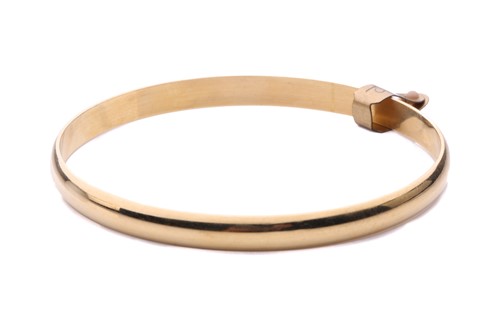 Lot 44 - An 18ct yellow gold closed bangle, with a...