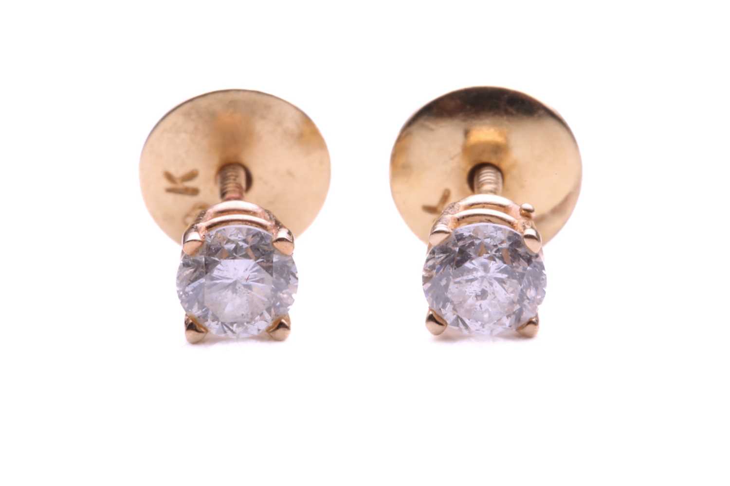 Lot 75 - A pair of single stone diamond earrings; the...