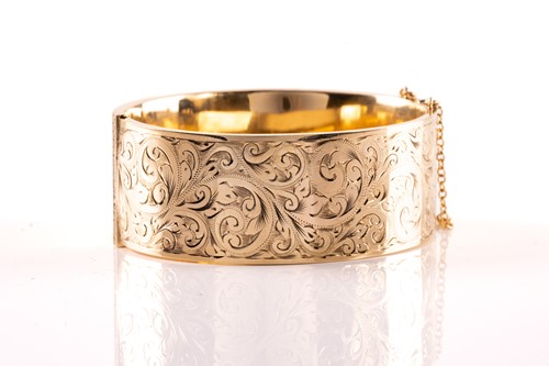 Lot 17 - A 9ct yellow gold hinged bangle, the hollow...