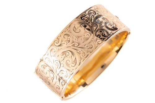 Lot 17 - A 9ct yellow gold hinged bangle, the hollow...