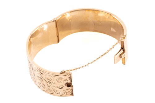 Lot 17 - A 9ct yellow gold hinged bangle, the hollow...