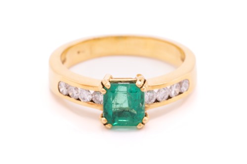 Lot 216 - An emerald and diamond dress ring in 18ct...